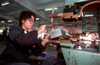 Dongguan, Guangdong province, China: metal worker operating a machine - Chinese factory worker - photo by B.Henry