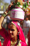 India - Rajasthan: Rashput woman with her typical jewels and clothes with a pot of water on her head - photo by E.Petitalot