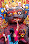 Kathmandu, Nepal: woman making a food offer to Kala Bhairava, ferocious manifestation of Shiva associated with annihilation - Hanuman Dhoka, Durbar square - photo by J.Pemberton