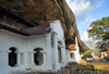 Dambulla, Central Province, Sri Lanka: arched colonnade under a overhanging rock slab - Dambulla cave temple - UNESCO World Heritage Site - photo by M.Torres