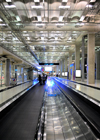 Bang Phli District, Samut Prakan Province, Thailand: Suvarnabhumi Airport, aka as New Bangkok International Airport - people on moving walkway in an industrial architecture environment - vanishing point - photo by M.Torres